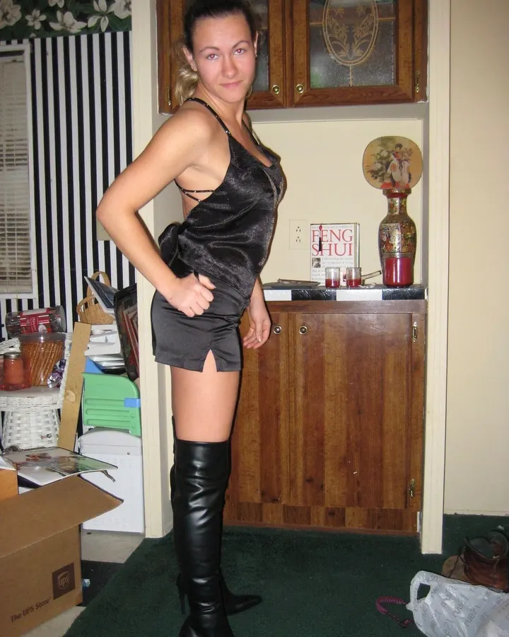 Femme blonde en tenue blanche, posant de face sur fond blanc, avec une expression sérieuse et des cheveux longs ondulés.