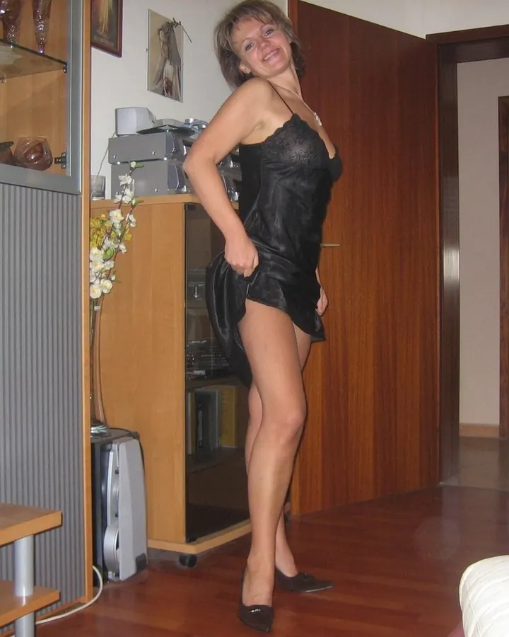 Femme blonde en robe blanche posant sur un port