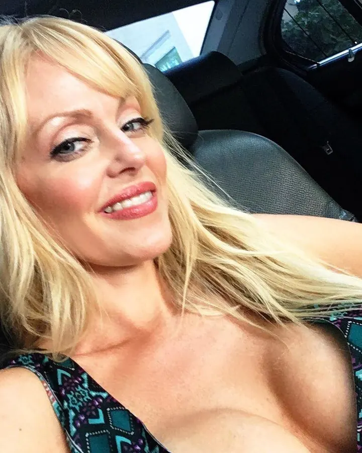 Femme aux cheveux blonds en bikini jaune, debout près d’une piscine, dos tourné.