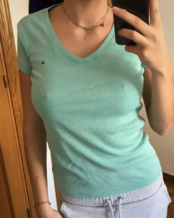 Femme aux cheveux châtains portant un ensemble de lingerie noire en dentelle, regardant directement l'appareil avec une main sur la hanche.